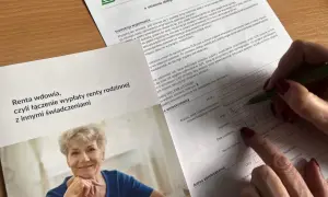 Kobieta wypełnia wniosek o rentę rodzinną po zmarłym ojcu, łącząc ją z innymi świadczeniami.
