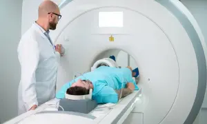 Pacjent leży w rezonansie magnetycznym. Lekarz obsługuje aparat. Tomografia prywatnie bez skierowania to szybka droga do diagnozy.