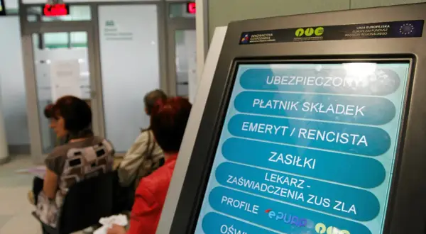 Terminal ZUS wyświetla opcje, w tym "LEKARZ - ZAŚWIADCZENIA ZUS ZLA". Ludzie czekają w kolejce.