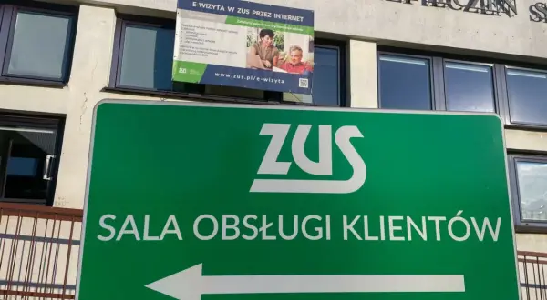 Zielony znak z logo ZUS i napisem "SALA OBSŁUGI KLIENTÓW" wskazuje drogę do placówki zarządzania socjalnego ubezpieczenia.