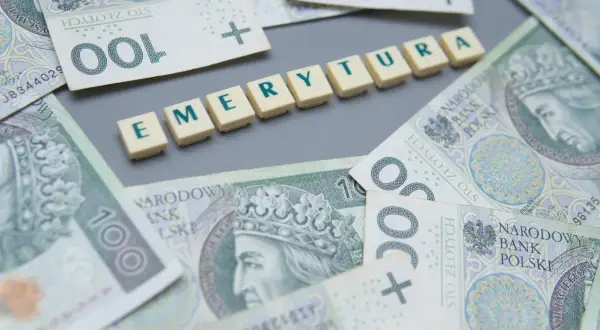 Pieniądze i litery układające się w słowo "EMERYTURA". Zastanawiasz się, ile wynosi minimalna emerytura w Polsce?