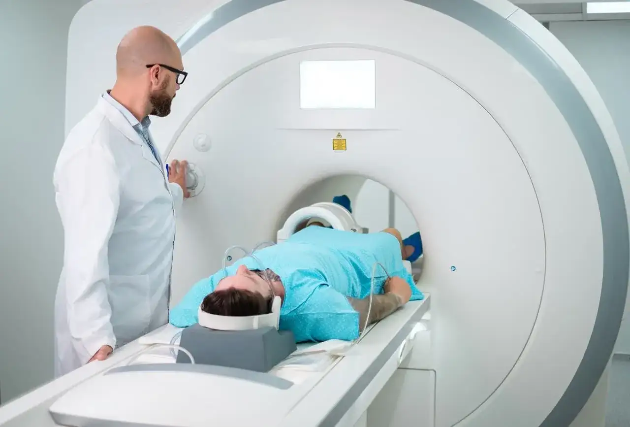 Pacjent leży w rezonansie magnetycznym. Lekarz obsługuje aparat. Tomografia prywatnie bez skierowania to szybka droga do diagnozy.