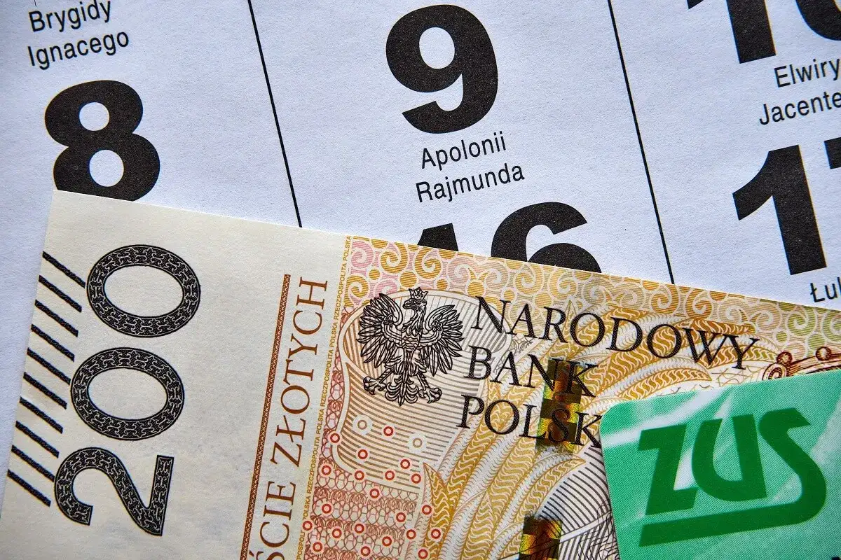 Kalendarz z datami i imieniami, banknot 200 zł i karta ZUS. Termin wypłaty emerytury zależy od dnia miesiąca.