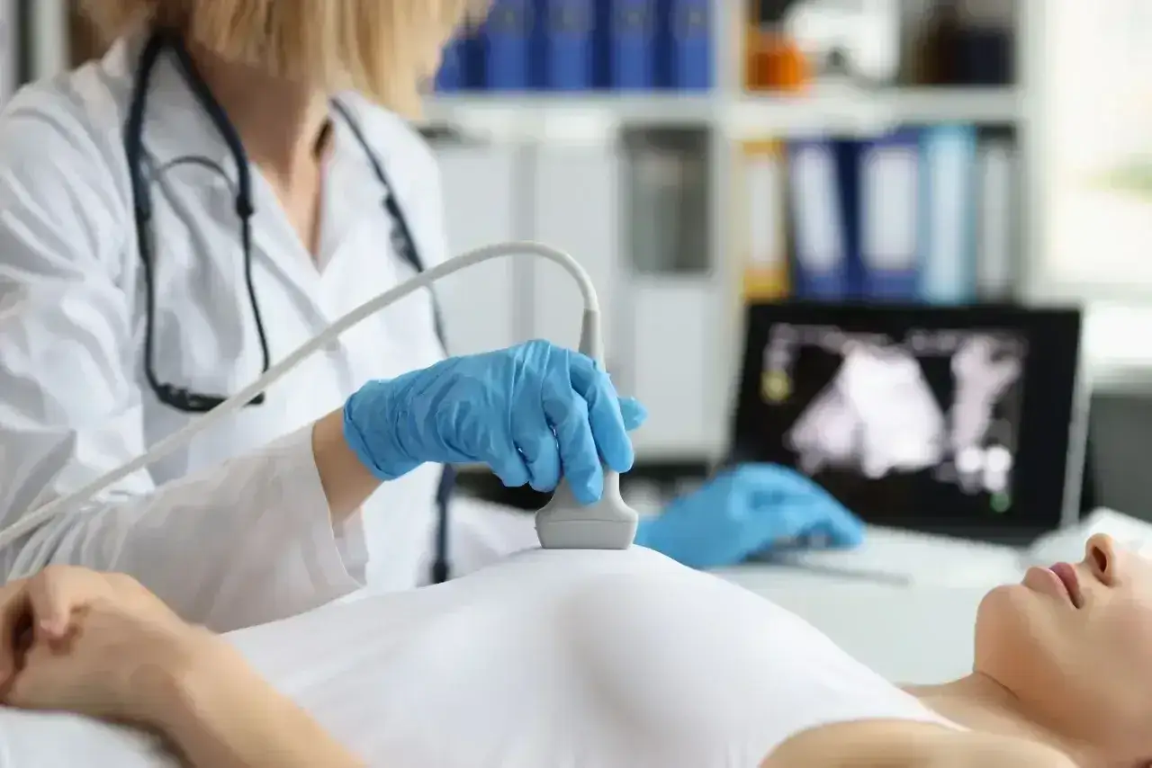 Lekarka wykonuje badanie USG piersi, analizując moja mammografia wyniki na ekranie komputera.