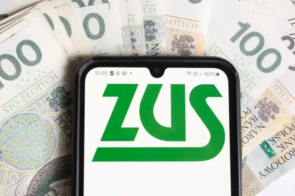 ZUS na ekranie telefonu, otoczony banknotami 100 zł. Sprawdzam, czy renta wdowia ma limit.